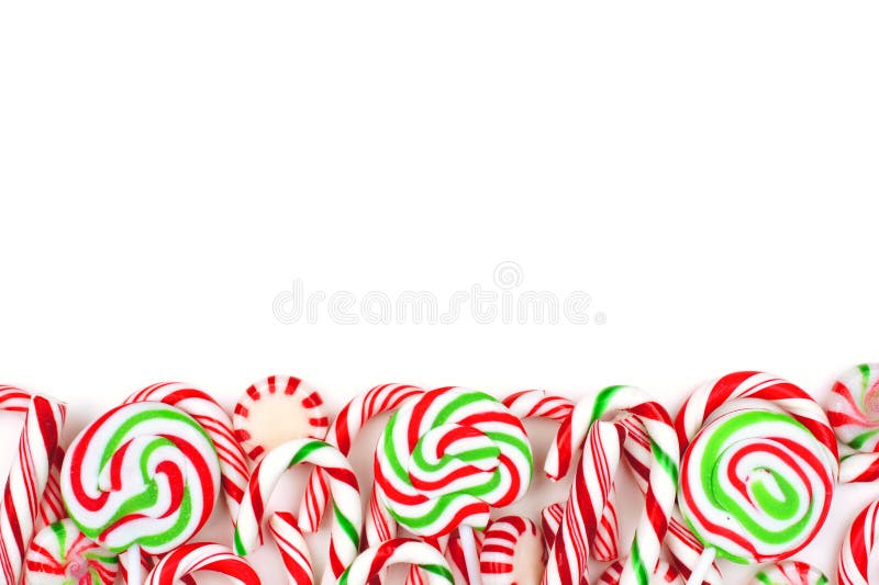 Christmas candy bottom border with lollipops, peppermints and candy canes over a white background. Christmas candy bottom border with lollipops, peppermints and candy canes over a white background