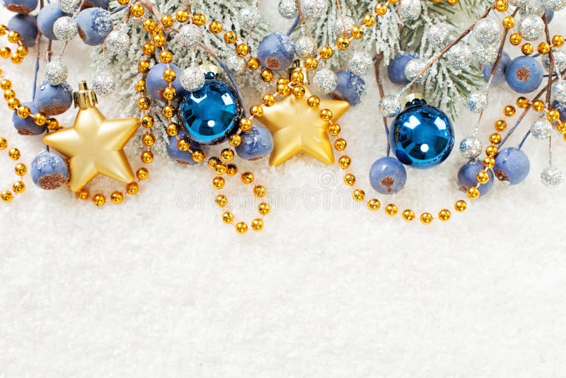 Christmas card border. Xmas composition with green fir branch, gold stars, blue baubles and berries on white snow background royalty free stock photography Christmas card border. Xmas composition with green fir branch, gold stars, blue baubles and berries on white snow background royalty free stock photography