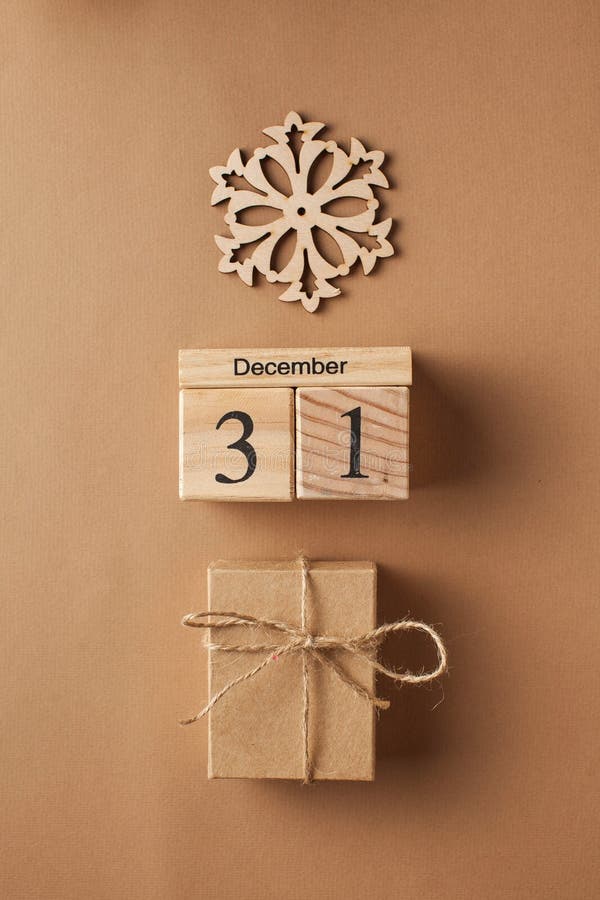 Christmas card. Christmas gift box, wooden calendar on December 31 and snowflake
