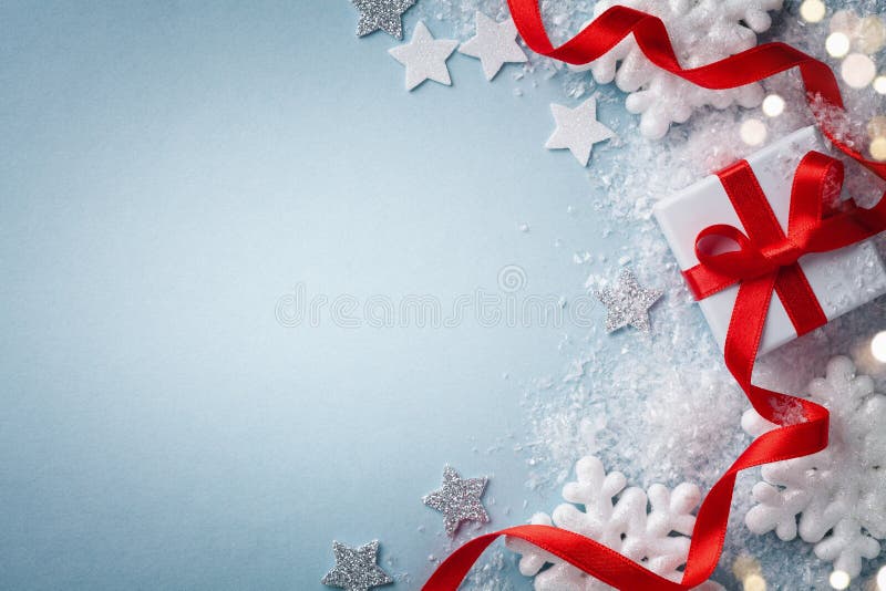 Christmas card. Gift or present box with red ribbon and holiday decoration on blue background top view. Happy New Year composition stock image Christmas card. Gift or present box with red ribbon and holiday decoration on blue background top view. Happy New Year composition stock image