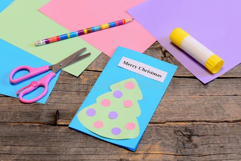 Christmas card tutorial. Paper greeting card with text Merry Christmas, pencil, glue stick, colored paper sheets, scissors royalty free stock photos Christmas card tutorial. Paper greeting card with text Merry Christmas, pencil, glue stick, colored paper sheets, scissors royalty free stock photos