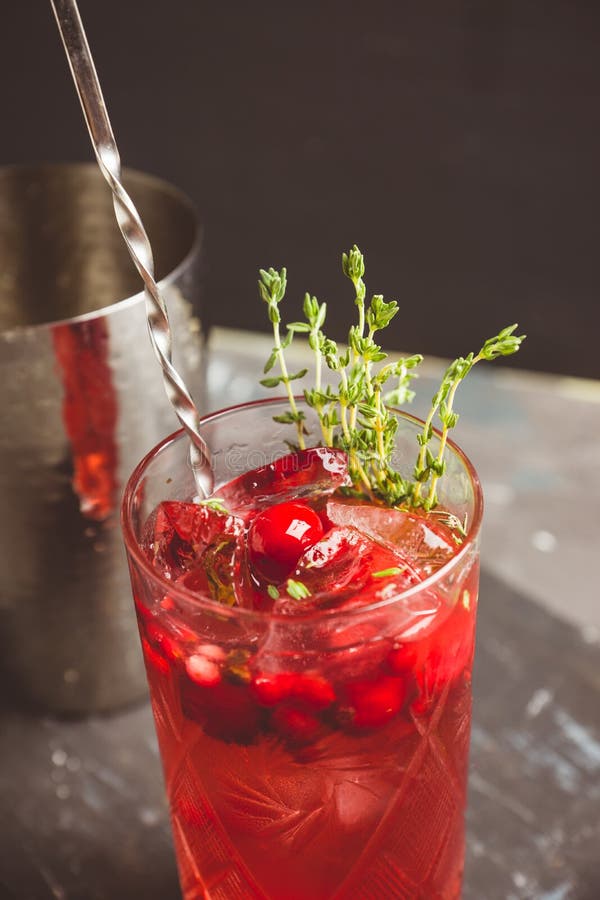 Christmas Cocktail with Berries and Thyme on the Rustic Background