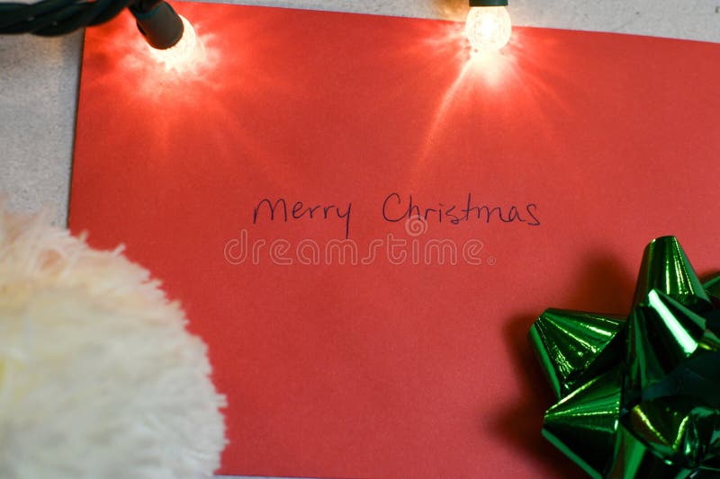 Christmas composition. Christmas hat, green bow, and an envelope with Merry Christmas written on it