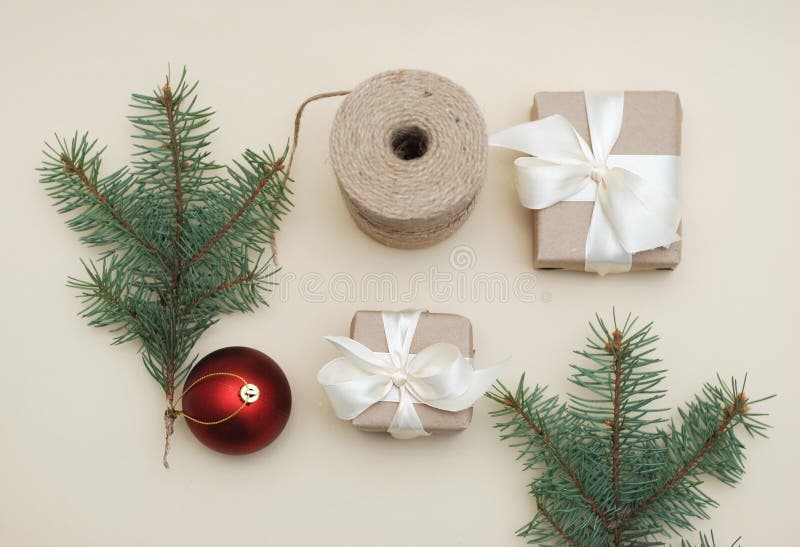 Gift box Wrapped in Brown Recycled Paper with White Ribbon Bow Top View  with Fir Branches. Christmas Concept. Close Up. Stock Photo