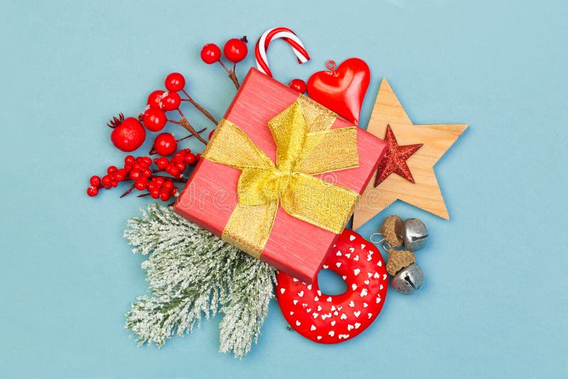 Christmas concept. Xmas composition with holly berries, gift and green fir branch on blue background stock images Christmas concept. Xmas composition with holly berries, gift and green fir branch on blue background stock images
