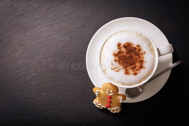 Christmas cookie and cup of cappuccino on dark background stock image