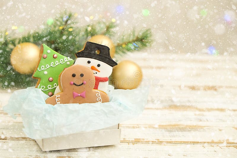 Christmas cookies in a box with gifts, lights and fir branches on white vintage wooden table. Snow effect, bokeh stock photography Christmas cookies in a box with gifts, lights and fir branches on white vintage wooden table. Snow effect, bokeh stock photography