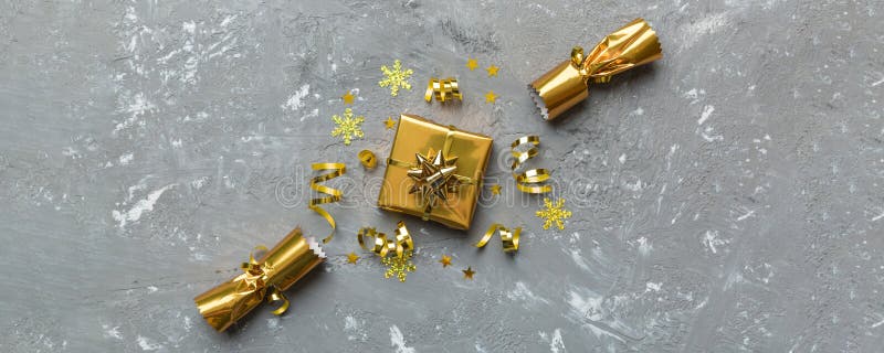 Christmas crackers with shiny confetti on color background, top view, copy space.
