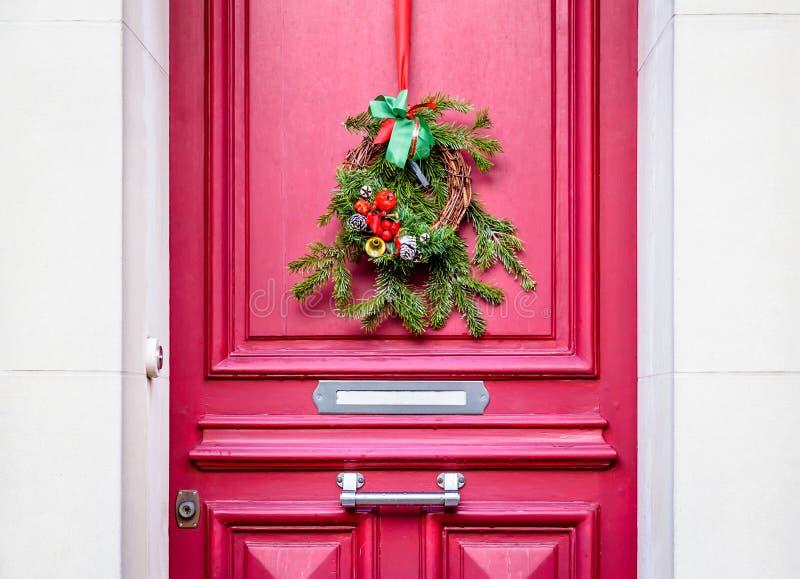 A Christmas Crown Hanging on a Red Front Door with Moldings Stock Photo ...