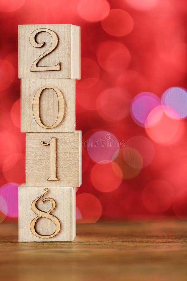 Christmas cubes on blurred red background. Children`s clumsy construction. The new year 2018.