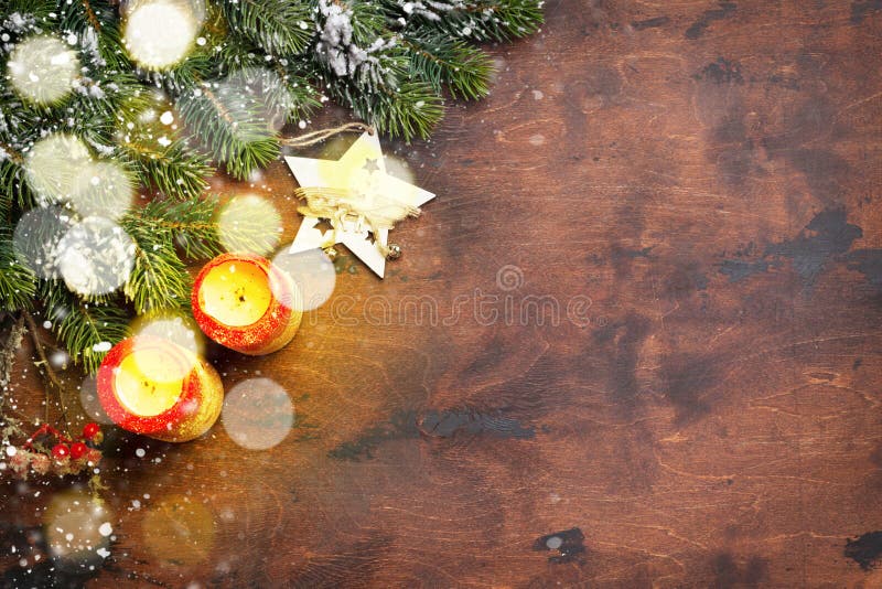 Christmas decor, candles and fir tree branch covered by snow on wooden background. Top view xmas backdrop with space for your royalty free stock image Christmas decor, candles and fir tree branch covered by snow on wooden background. Top view xmas backdrop with space for your royalty free stock image