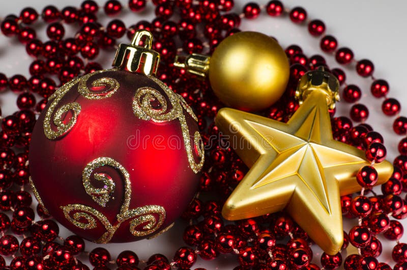Christmas decoration of big and small glass ball and gold star with red chain as background. Christmas decoration of big and small glass ball and gold star with red chain as background