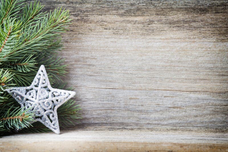 Christmas decoration with fir branches on the wood background.