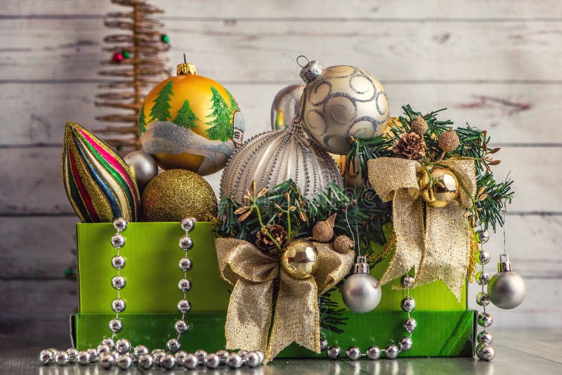 Christmas decorations in green box on light wooden background