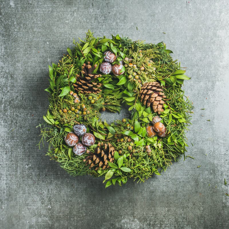 Christmas decorative wreath over grey concrete wall background, square crop