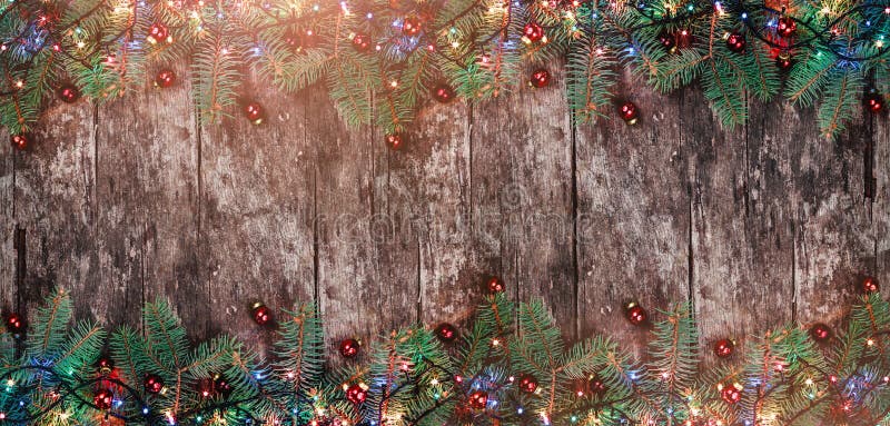 Christmas Fir branches with lights and red decorations on wooden background. Xmas and Happy New Year frame. royalty free stock photo Christmas Fir branches with lights and red decorations on wooden background. Xmas and Happy New Year frame. royalty free stock photo