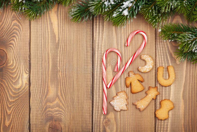 Christmas fir tree with snow, candy cane and gingerbread cookies