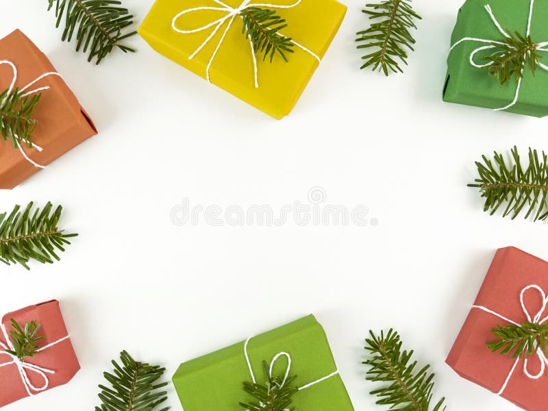 Christmas flat lay with copy space in the middle. Holiday postcard with fir tree branches and gift boxes on a white stock photography