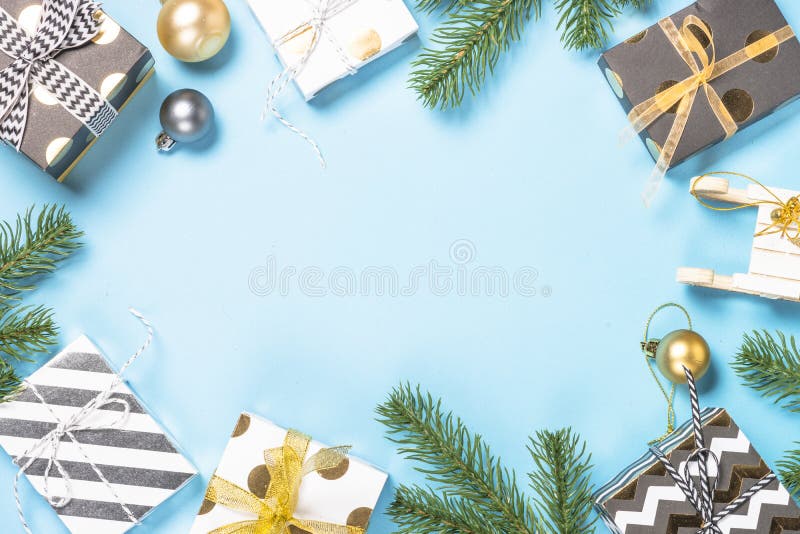Christmas flatlay background - fir tree and decorations on blue. Christmas flatlay background. Snow Fir tree branch, blue and gold decorations and present box on royalty free stock image Christmas flatlay background - fir tree and decorations on blue. Christmas flatlay background. Snow Fir tree branch, blue and gold decorations and present box on royalty free stock image