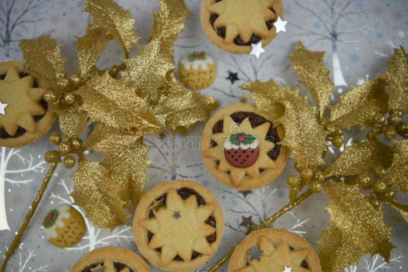 Christmas food photography picture with seasonal pastry mince pies and gold glitter covered holly with pudding decorations royalty free stock images Christmas food photography picture with seasonal pastry mince pies and gold glitter covered holly with pudding decorations royalty free stock images