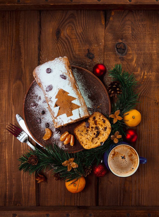 Christmas fruitcake powdered sugar tangerine fir tree festive decoration wooden background flat lay. Stollen cake loaf