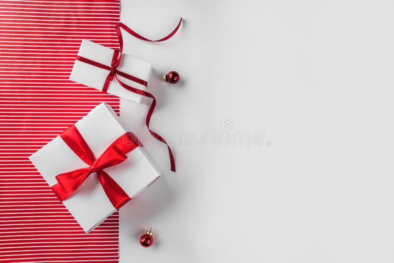 Thin, red and white ribbon is laid out on a plain white background