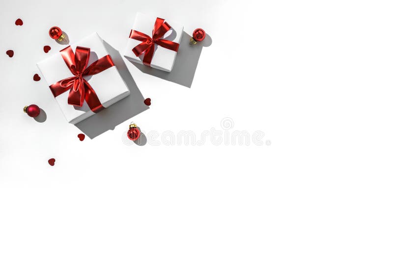 Christmas gift boxes with red ribbon, sparkles, confetti and decoration on white background. Xmas and Happy New Year holiday