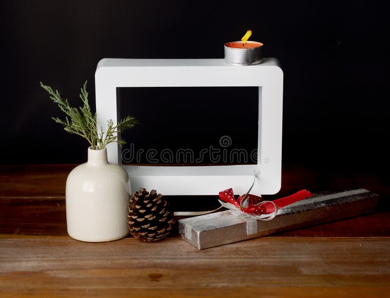 Christmas gift with empty picture frame on wooden table