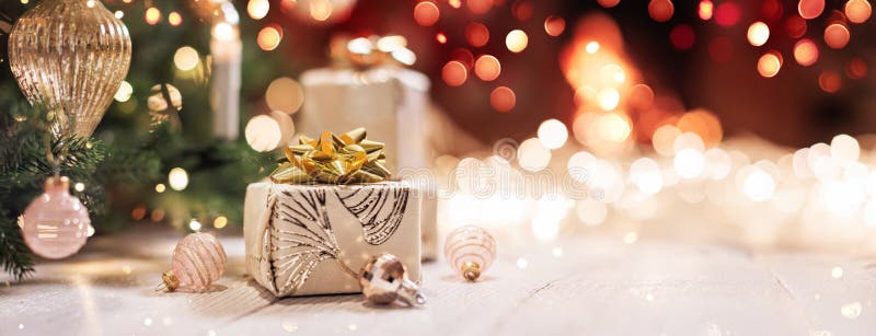 Christmas gifts with bright illumination lights on a light wooden background