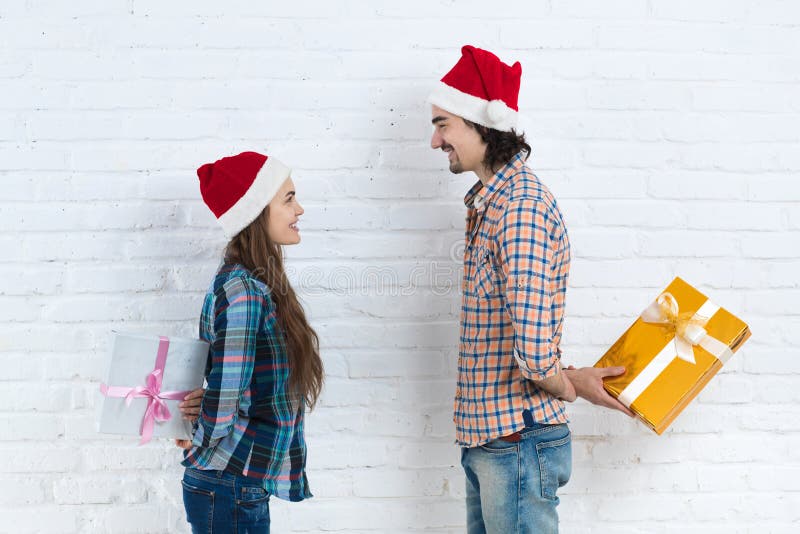 Christmas Holiday Happy Couple Hold Surprise Present Boxes Wear New Year Santa Hat Cap, Man And Woman Smiling