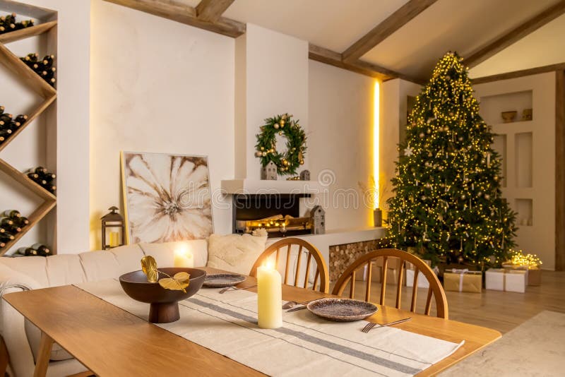 Christmas interior of a living room in a country house. Fireplace, sofa, table with candles and a Christmas tree with a garland.