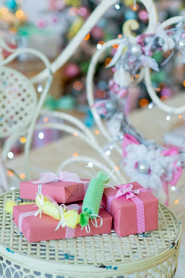 Árbol de navidad regalos junto a una cama, piso lámpara, martillado hierro sillas a mesa.