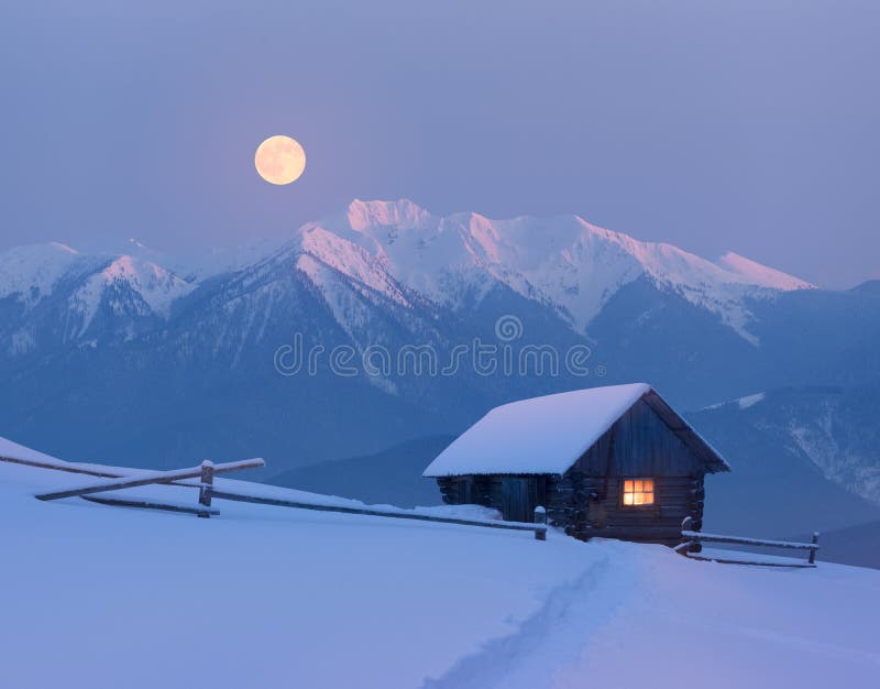 Christmas landscape with a snowy house in the mountains on a moonlit night