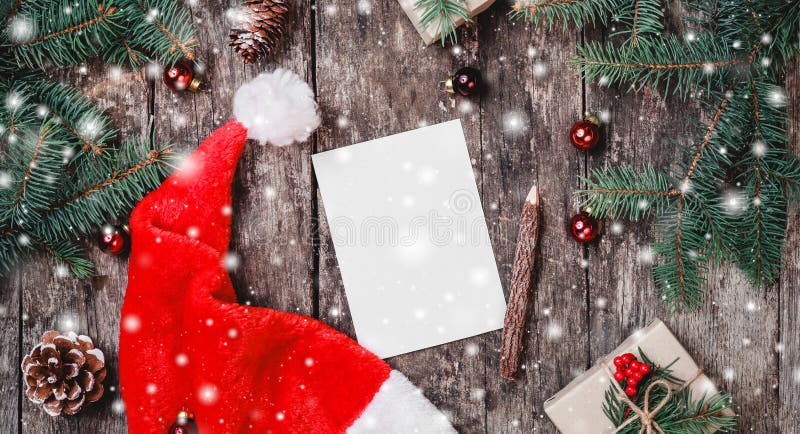 Christmas letter on wooden background with red Santa hat, Fir branches, pine cones, red decorations. Xmas and Happy New Year. Composition. Flat lay, top view stock photo Christmas letter on wooden background with red Santa hat, Fir branches, pine cones, red decorations. Xmas and Happy New Year. Composition. Flat lay, top view stock photo