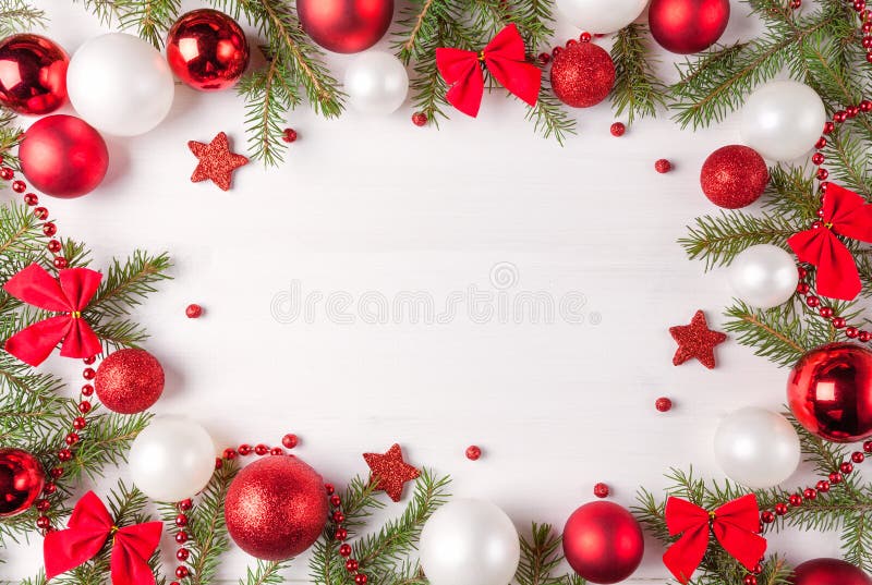 Christmas light frame decorated with red and white baubles, bows and fir branches. Copy space in center