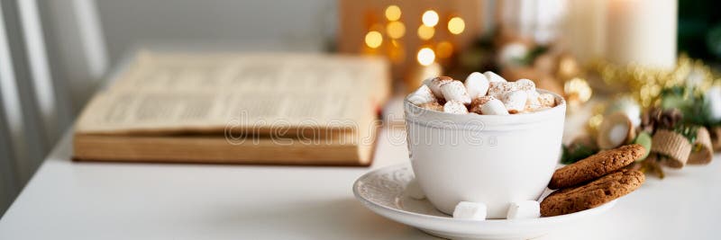 Christmas light gray background with copy space. Reading book on cozy winter evening with candles