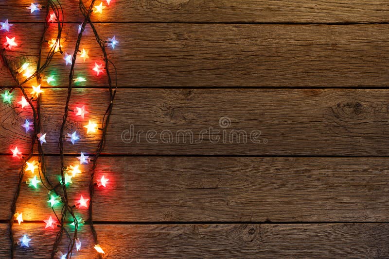 Christmas lights border on wood background