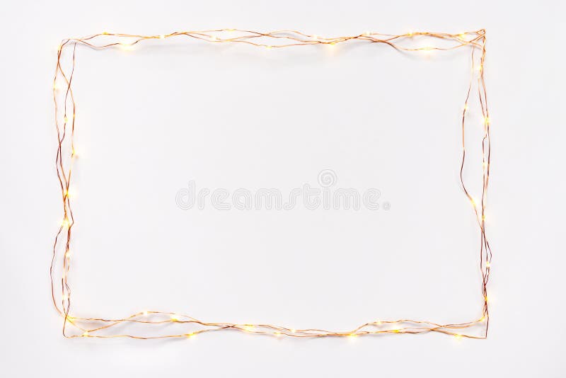 Christmas lights garland border over white background. Flat lay, copy space. royalty free stock photo