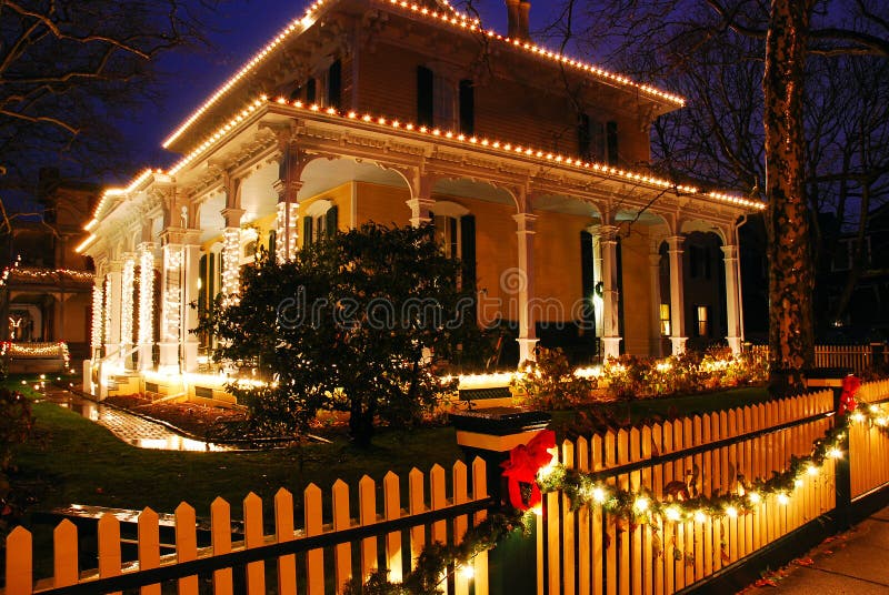 Christmas lights and holly decorate a Victorian Home. At dusk in Cape May New Jersey