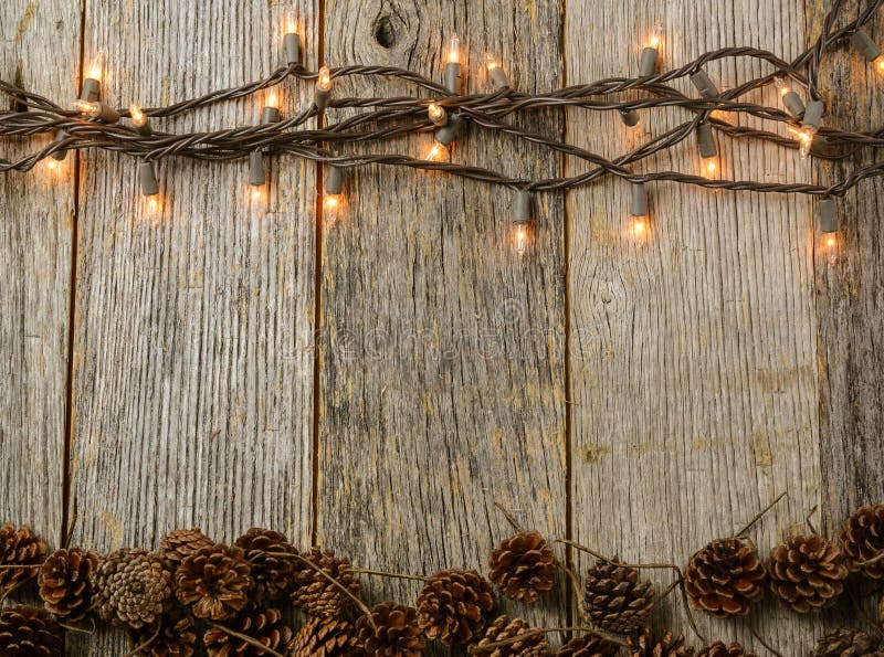 Christmas Lights and Pine cones on Rustic Wood stock photos
