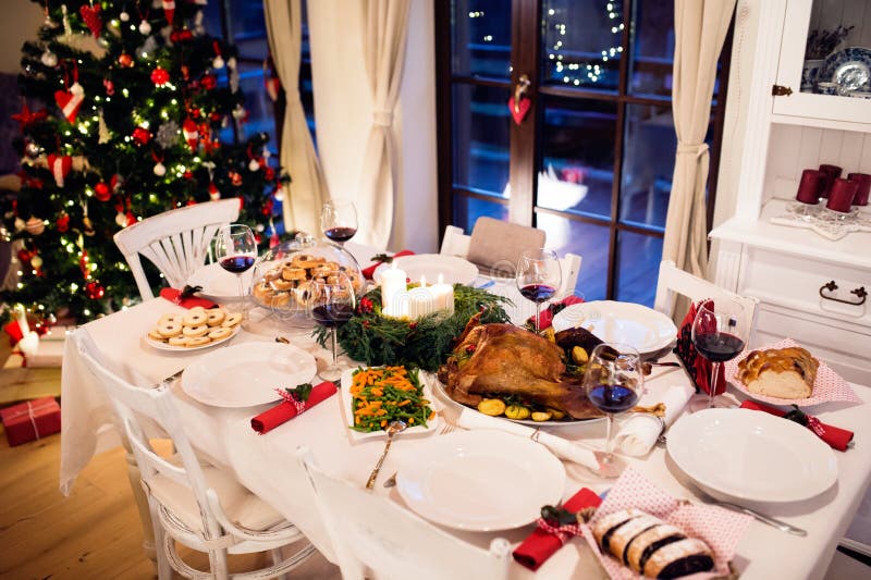 Christmas meal laid on table in decorated dining room.