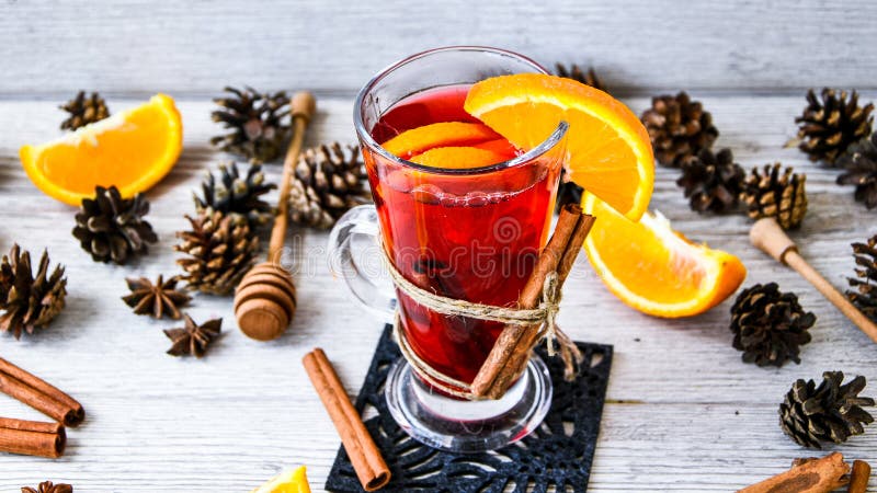 Christmas mulled wine with spices and orange on wooden rustic background. Selective focus. Anise stars and cinnamon sticks.