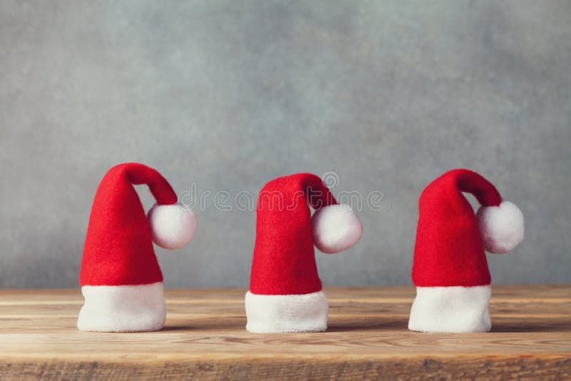 Christmas and New year concept with little Santa Claus hats on wooden background. Holiday greeting card. stock image Christmas and New year concept with little Santa Claus hats on wooden background. Holiday greeting card. stock image