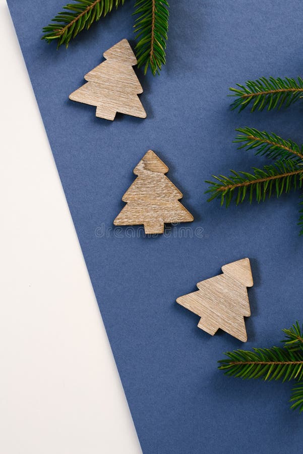 Christmas or new year decorations wooden Christmas trees and tree branches on blue background with copy space for text. Christmas, stock image Christmas or new year decorations wooden Christmas trees and tree branches on blue background with copy space for text. Christmas, stock image