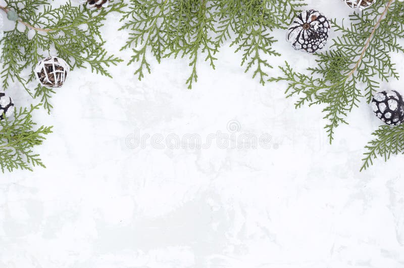 Christmas New Year flat lay frame made from pine cones and fir branches on white snow texture. Mockup with copy space stock image Christmas New Year flat lay frame made from pine cones and fir branches on white snow texture. Mockup with copy space stock image