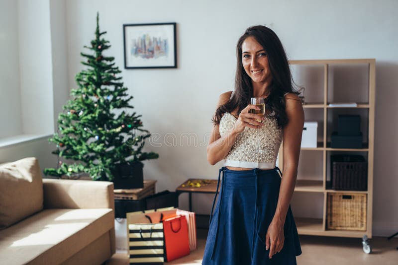 Christmas, New Year. Happy young woman with glass of champagne at home royalty free stock photography Christmas, New Year. Happy young woman with glass of champagne at home royalty free stock photography