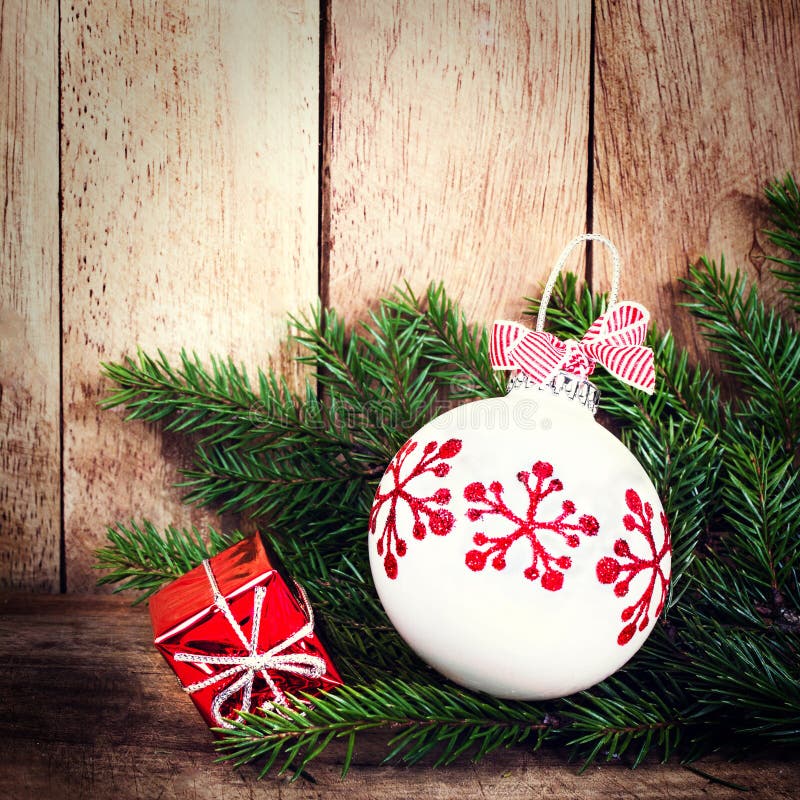 Christmas Ornaments with fir tree branch over wood wall. Vintage royalty free stock photo Christmas Ornaments with fir tree branch over wood wall. Vintage royalty free stock photo