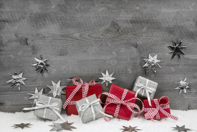 Christmas presents in red and silver on wooden grey background.