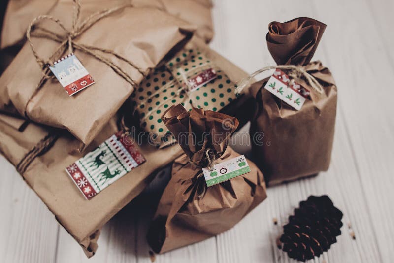 Christmas presents. rustic craft presents on white wooden background top view. stylish simple gifts wrapped in brown paper for christmas holidays. eco design. xmas seasonal greetings