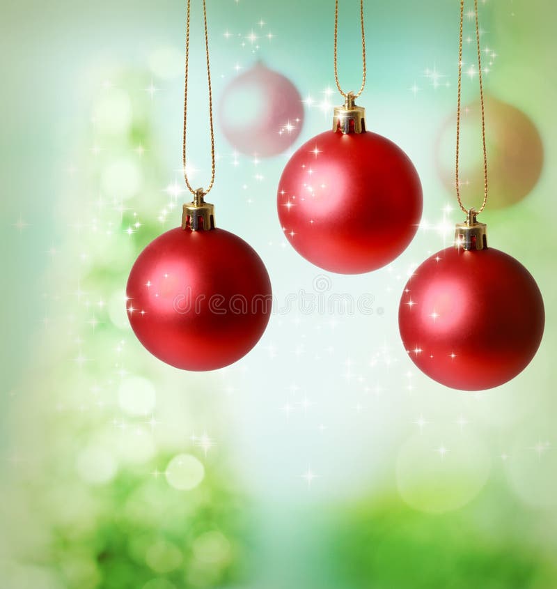 Christmas red ornaments over green tree lights background